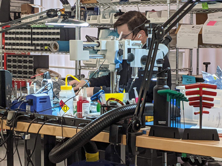 Worker at bench in robot lab